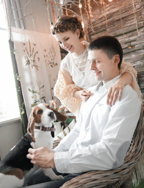 young couple with pet sitting on a chair - Foto, Imagen