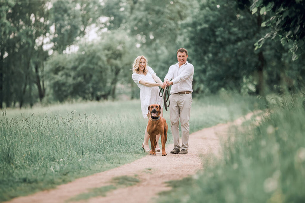 young husband and his wife have fun with their pet dog - Foto, afbeelding