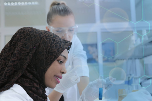 Zwei multiethnische junge Wissenschaftlerinnen experimentieren im Labor - Foto, Bild