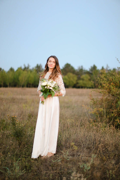 Caucasian bride with white bouquet background in steppe background. - Foto, immagini