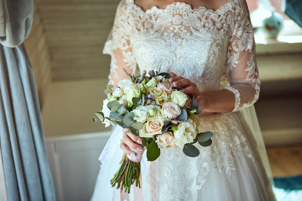 bouquet in hands of the bride, woman getting ready before wedding ceremony - Φωτογραφία, εικόνα