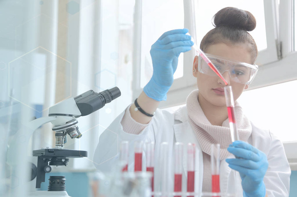 Νεαρή γυναίκα Εργαστηριακός επιστήμονας που εργάζεται στο εργαστήριο με δοκιμαστικούς σωλήνες - Φωτογραφία, εικόνα