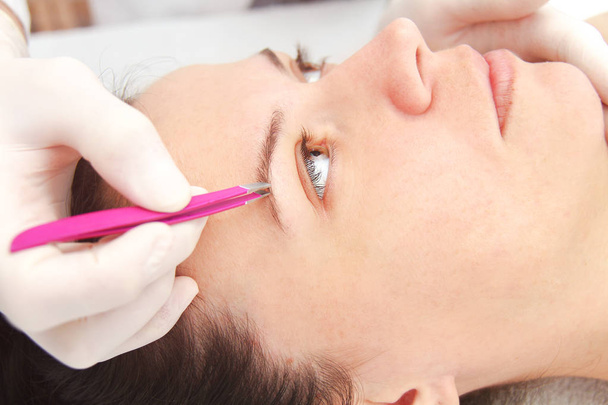 Young woman having professional eyebrow correction procedure in  - Photo, Image