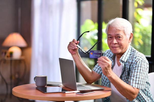 Asiático homem sênior usando cartão de crédito para compras online
 - Foto, Imagem