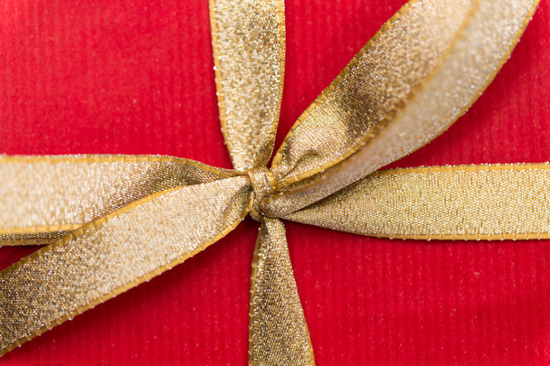 close up of christmas red gift box with golden bow - Foto, afbeelding