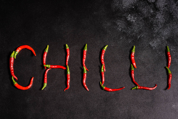 Bright red chilli pepper on a grey concrete background. Spicy food, ingredients - Foto, afbeelding