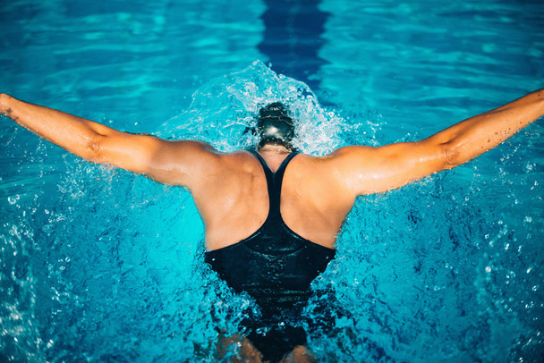 Vrouwelijke zwemmen vlinder in het zwembad - Foto, afbeelding