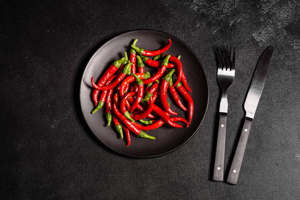 leuchtend rote Chilischoten auf grauem Betongrund. würzige Speisen, Zutaten - Foto, Bild
