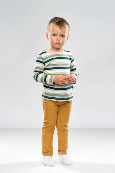 portrait of sad little boy in striped shirt - Фото, зображення