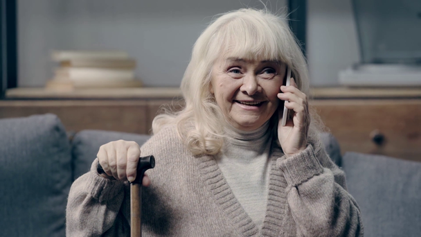 Sorrindo mulher idosa falando no smartphone
  - Filmagem, Vídeo
