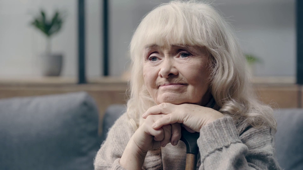 Zdenerwowana seniorka z demencją trzymająca laskę - Materiał filmowy, wideo