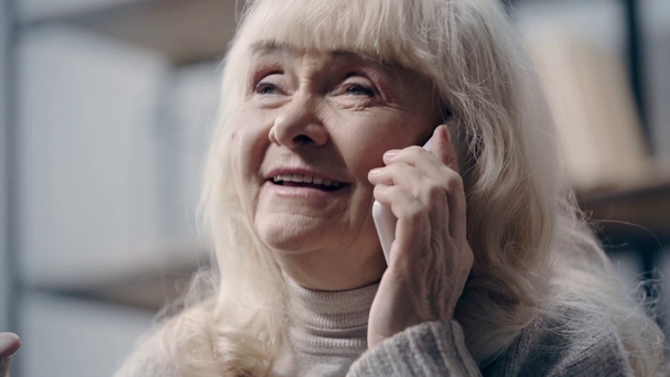 Улыбающаяся пожилая женщина разговаривает по смартфону
 - Кадры, видео