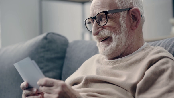 Starší muž s demencí se dívá na fotky - Záběry, video