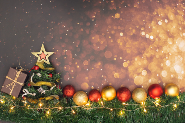 キラキラした背景に小さなクリスマスツリーとクリスマスの装飾  - 写真・画像
