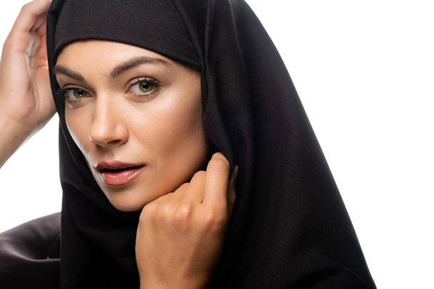 beautiful young Muslim woman in hijab with hands near face isolated on white - Foto, afbeelding