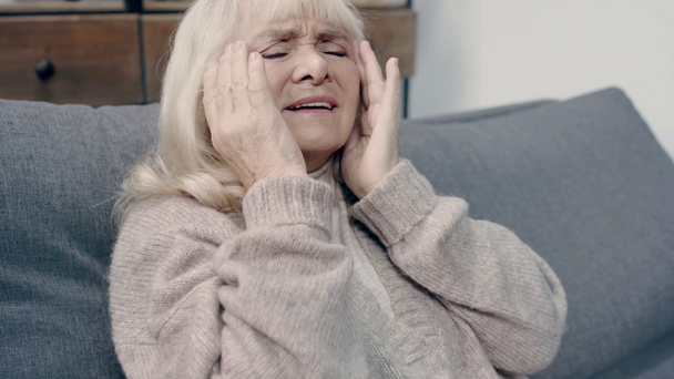 Κουρασμένη ηλικιωμένη γυναίκα με άνοια που έχει πονοκέφαλο  - Πλάνα, βίντεο