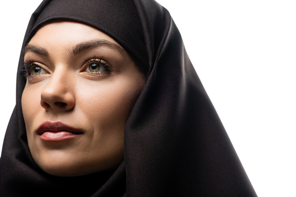 красивая молодая мусульманка в хиджабе смотрит в сторону изолированных на белом
 - Фото, изображение