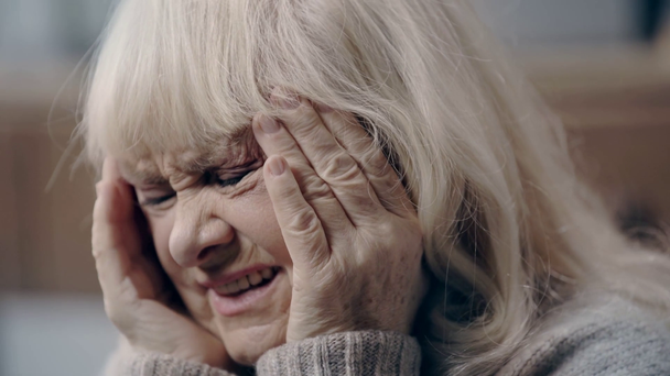 Moe oudere vrouw met dementie met hoofdpijn  - Video