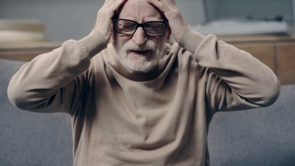 Oudere man met dementie met hoofdpijn en ontroerend hoofd - Video