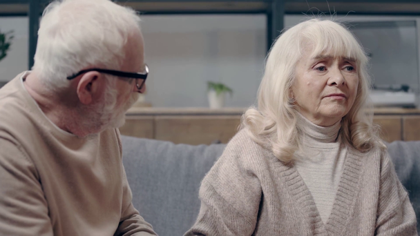 Senior man calming down upset wife with dementia - Materiał filmowy, wideo