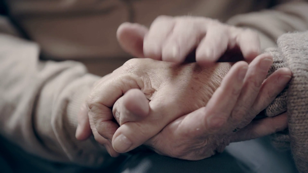 Idősebb férfi simogatja a nő kezét - Felvétel, videó