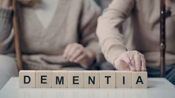 Starsza para ze słowem demencja na kostkach - Materiał filmowy, wideo