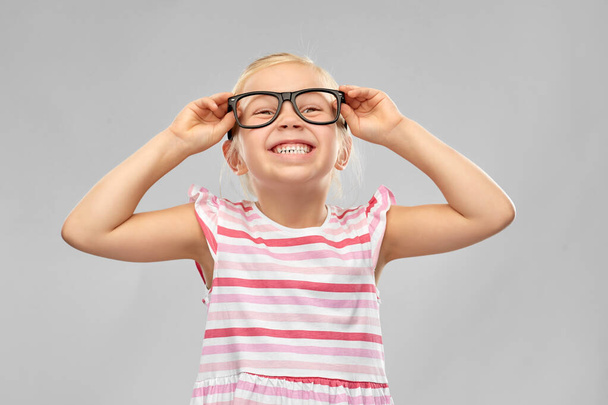 smiling cute little girl in black glasses - Fotoğraf, Görsel
