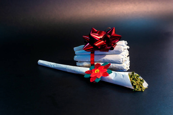 Un grande spinello di marijuana con una decorazione festiva di fronte
 - Foto, immagini