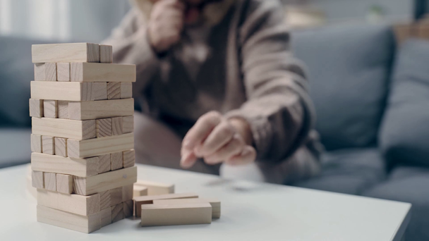 Senior vrouw met dementie spelen in blokken hout spel - Video