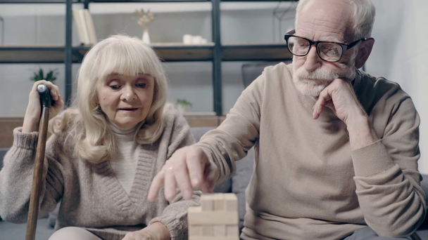 Seniorenpaar mit Demenz spielt gemeinsam in Holzklötzen  - Filmmaterial, Video