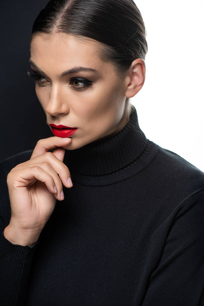 beautiful woman with red lips and hand on chin isolated on white and black - Zdjęcie, obraz