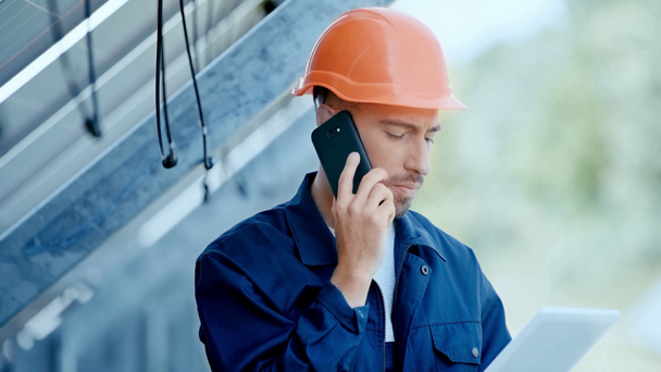 engineer talking on smartphone near solar battery  - Video