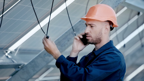 engineer checking wire and talking on smartphone  - Imágenes, Vídeo