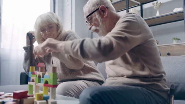 Senior couple with dementia stacking building blocks  - 映像、動画