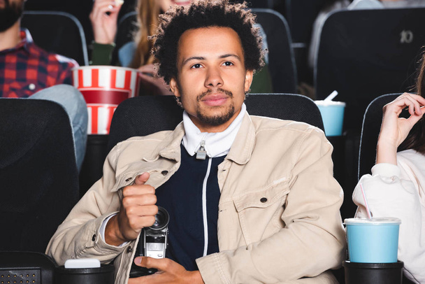 szelektív fókusz afro-amerikai férfi forgatás digitális fényképezőgép és filmet nézni a moziban  - Fotó, kép
