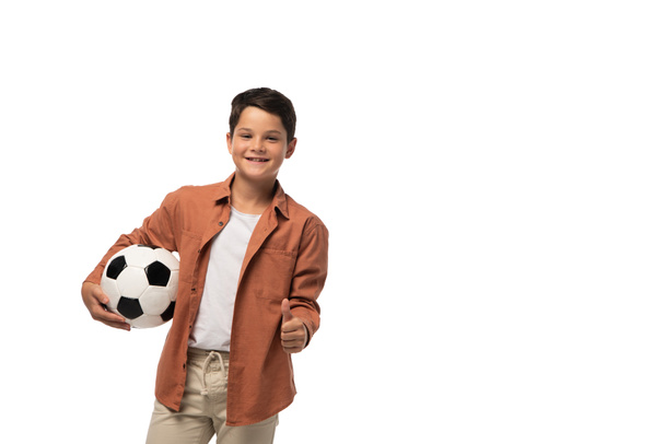 cheerful boy holding soccer ball and showing thumb up isolated on white - Photo, Image