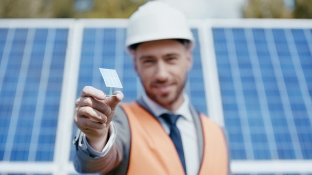 uśmiechnięty biznesmen pokazujący model baterii słonecznej  - Materiał filmowy, wideo