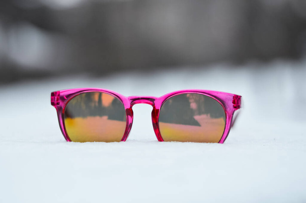 冬の雪の上の子供ピンクのサングラス - 写真・画像