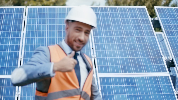 бизнесмен машет, указывая на солнечную панель, показывая, как
  - Кадры, видео
