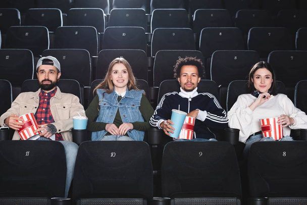 multicultural friends smiling and watching movie in cinema  - Foto, imagen