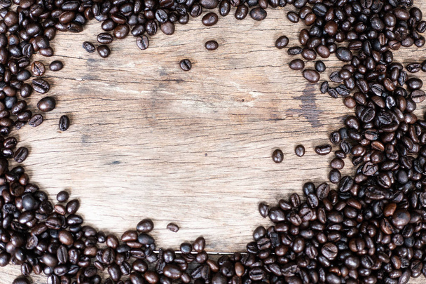 Жареный Арабика кофейных зерен на деревянном фоне
 - Фото, изображение