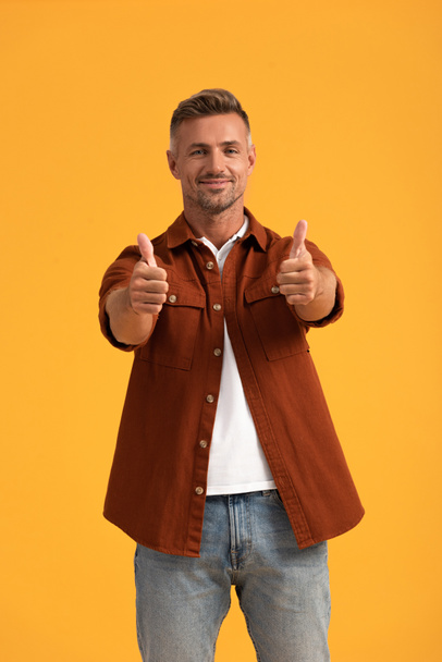 cheerful man showing thumbs up isolated on orange  - Fotografie, Obrázek