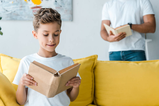 cropped view of father and son holding books at home  - Foto, afbeelding