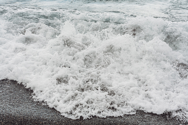mousse de mer blanche sur la plage de sable fin
  - Photo, image