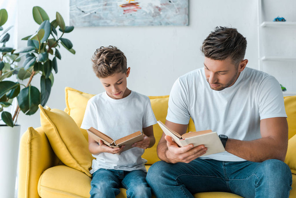handsome father and son reading books at home  - Фото, зображення