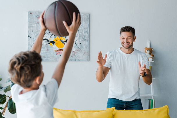 幸せな父親の選択的焦点はバスケットボールで息子を見て  - 写真・画像