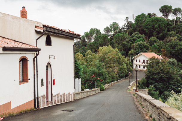 małe domki w pobliżu zielonych drzew i drogi we Włoszech  - Zdjęcie, obraz
