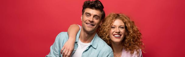 portrait of beautiful happy couple in casual clothes isolated on red - Foto, immagini