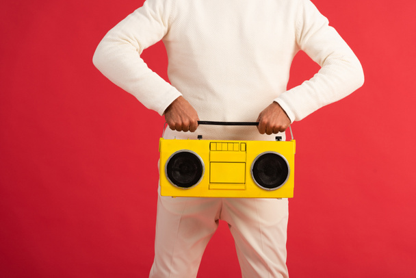 cropped view of man holding retro boombox isolated on red  - Φωτογραφία, εικόνα