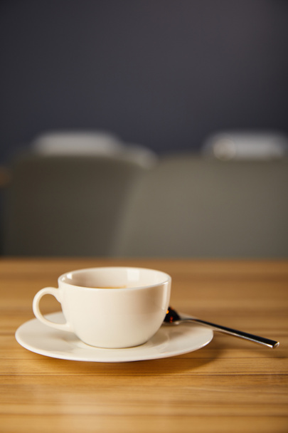 selective focus of white cup with hot coffee near spoon in cafe  - Fotoğraf, Görsel